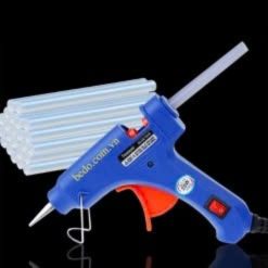Súng bắn keo nến màu xanh bên các thanh keo trên nền đen