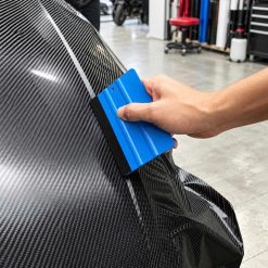 Tay cầm gạt cạnh nỉ miết trên bề mặt decal vân carbon