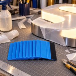 Gạt decal lưỡi nỉ màu xanh đặt cạnh chữ nổi sáng đèn
